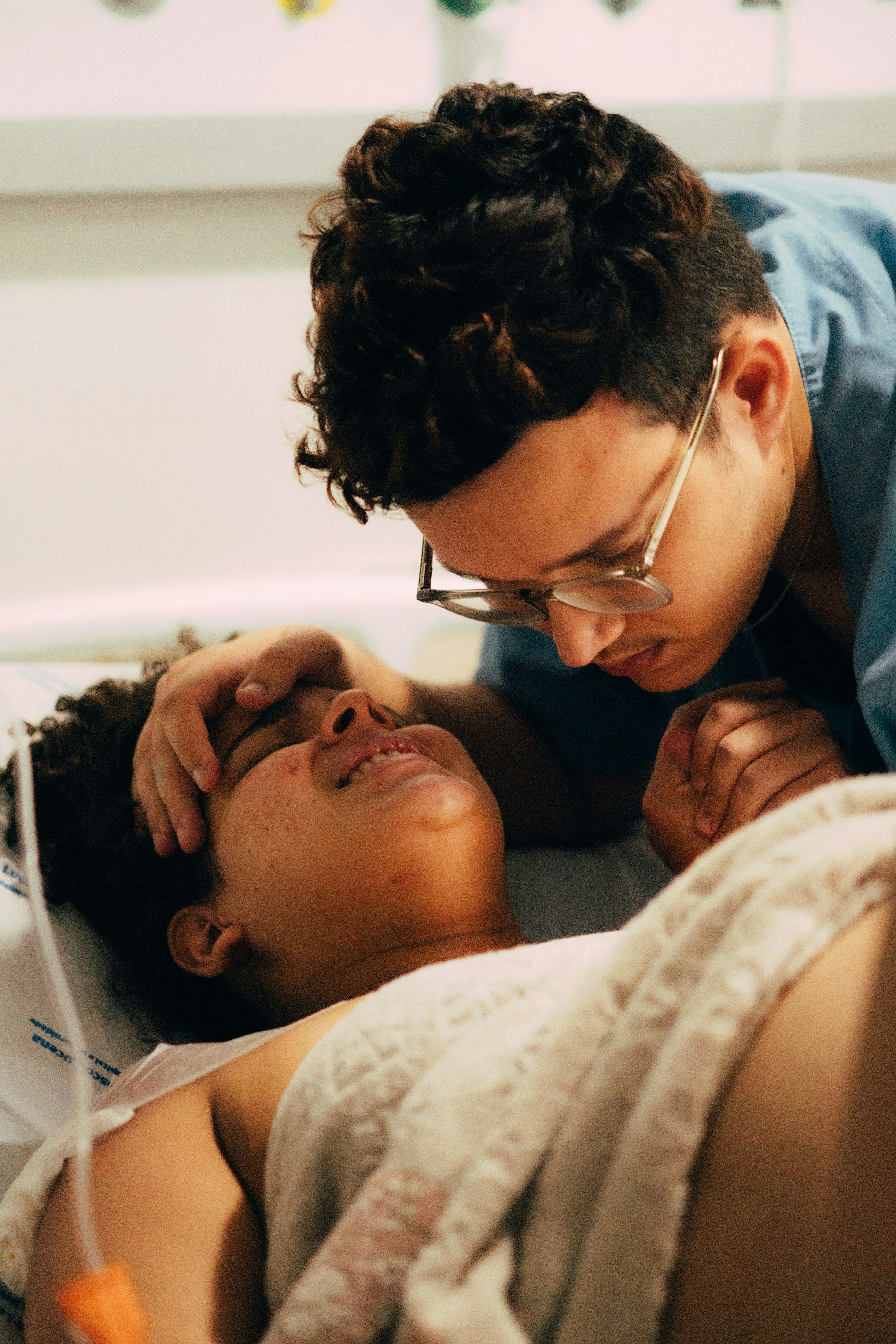 Birth partner supporting pregnant woman during labor in delivery room